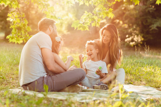 Familia joven disfrutando de un picnic al aire libre mientras cuidan su salud con productos 4Life.