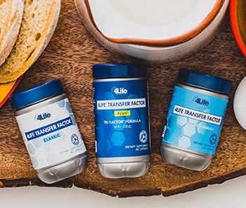 Suplementos 4Life Transfer Factor sobre una tabla de madera. Refuerzan el sistema inmunitario de forma natural.